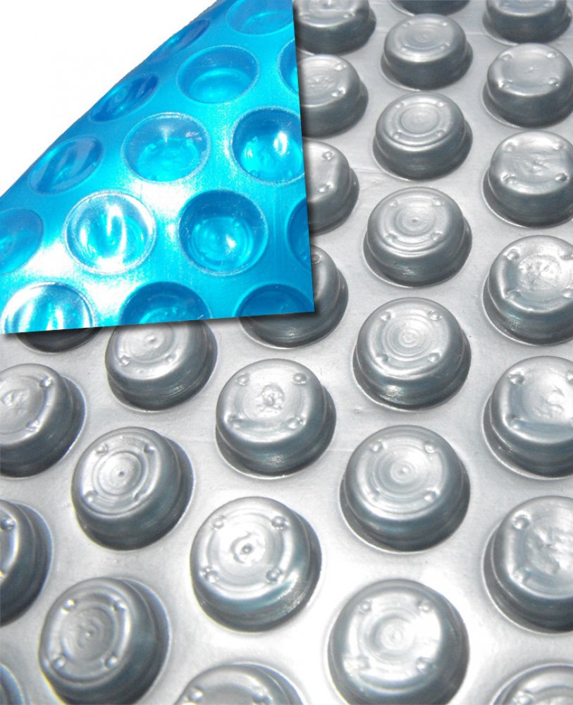 Close-up of the Swimming Pool Discounters 16ft x 24ft Rectangular Space Age Solar Cover in gray and blue, showing its raised circular bumps and lifted corner revealing the patterned blue underside for pool heat retention.