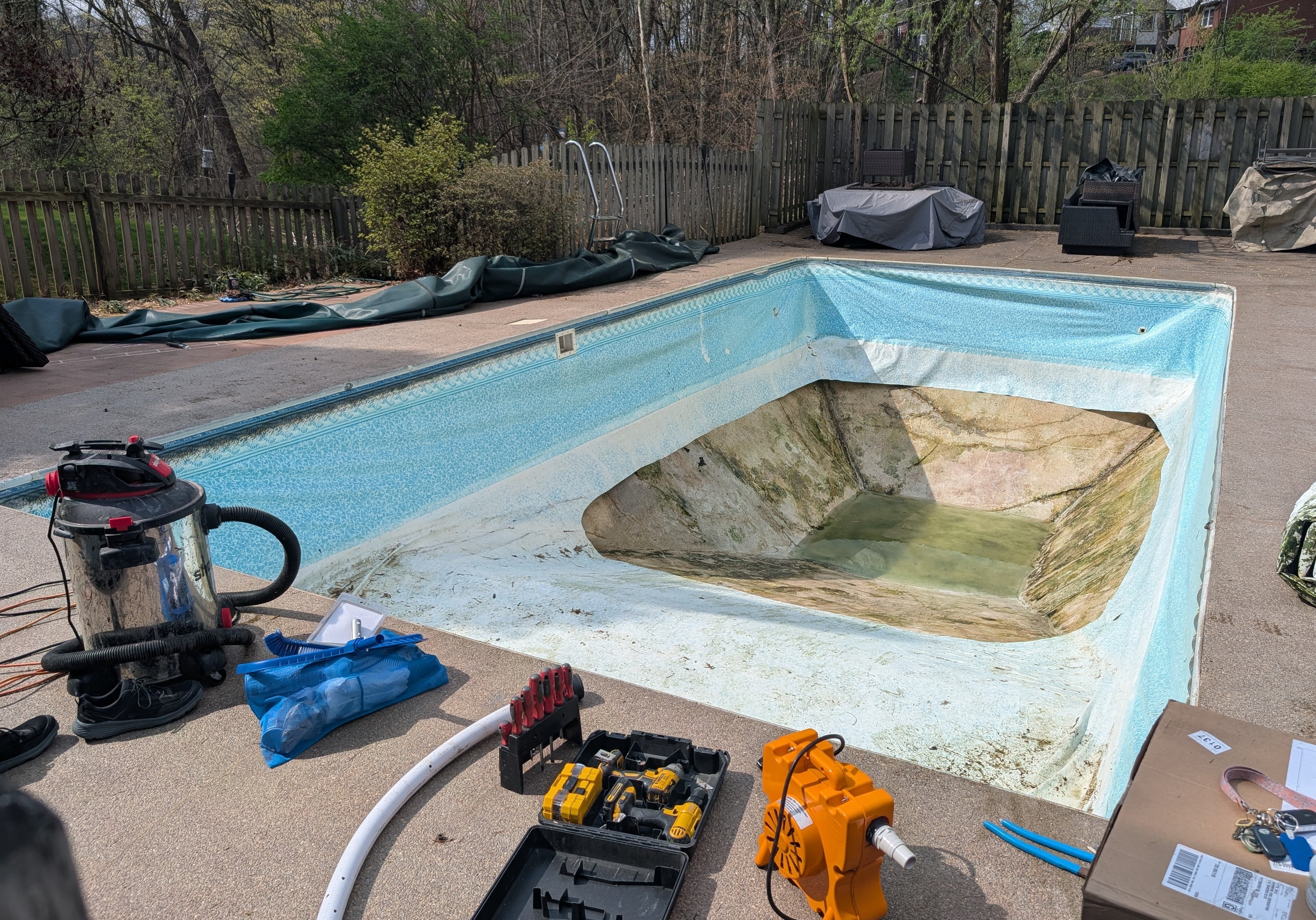Pool under renovation with tools and equipment on the ground
