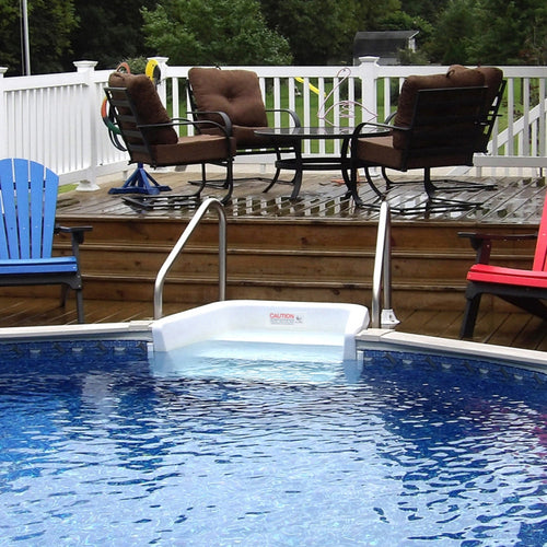 The H.I.I. Embassy 24' Round Silver Interlude 8" Premium Resin Frame Salt Friendly Semi In-Ground Pool features clear blue water, a white in-step, and a wooden deck with colorful Adirondack chairs and a white railing.