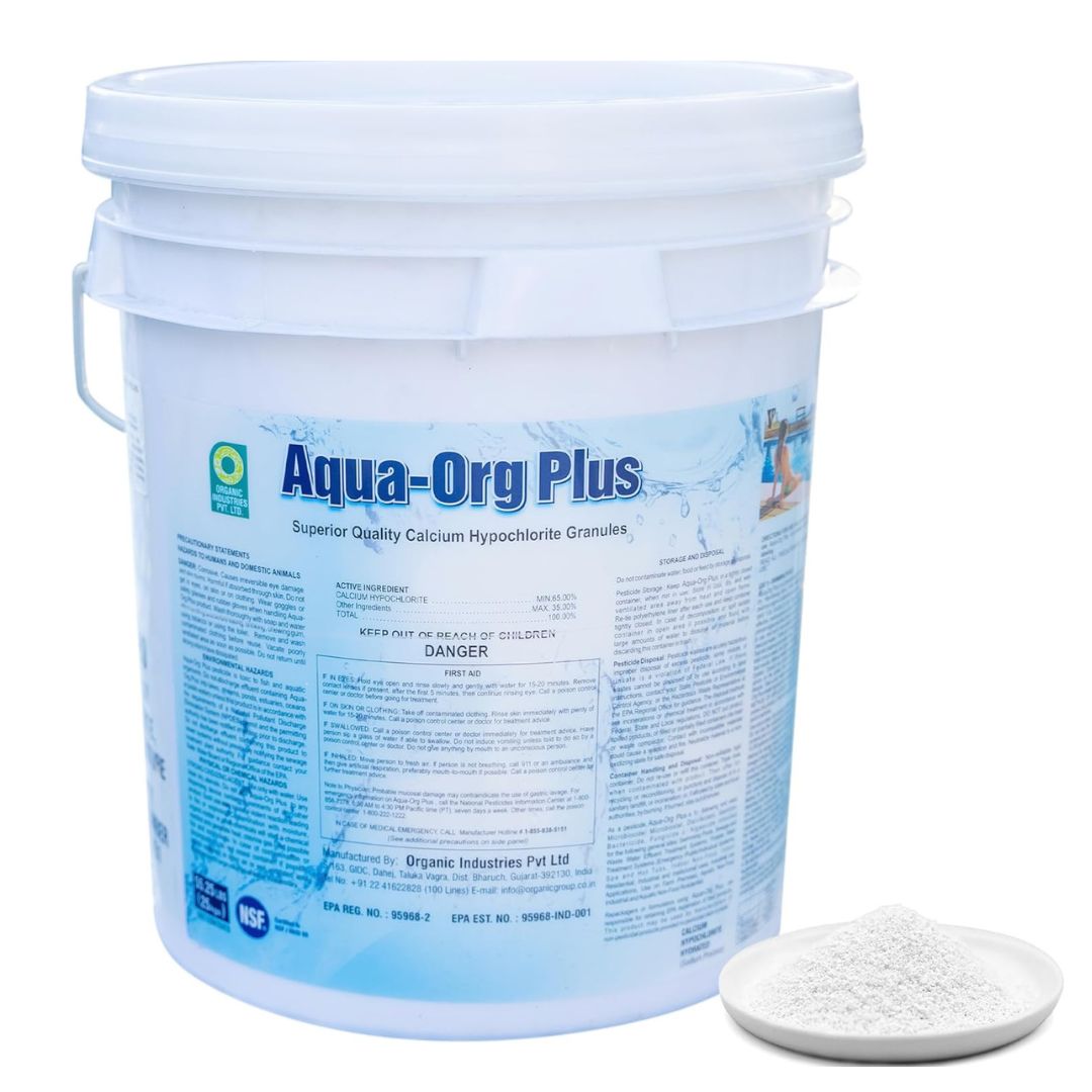 A white plastic bucket labeled Aqua-Organic Plus Calcium Hypochlorite Granules from Swimming Pool Discounters stands behind a small white dish holding the granules, used for swimming pool water treatment.