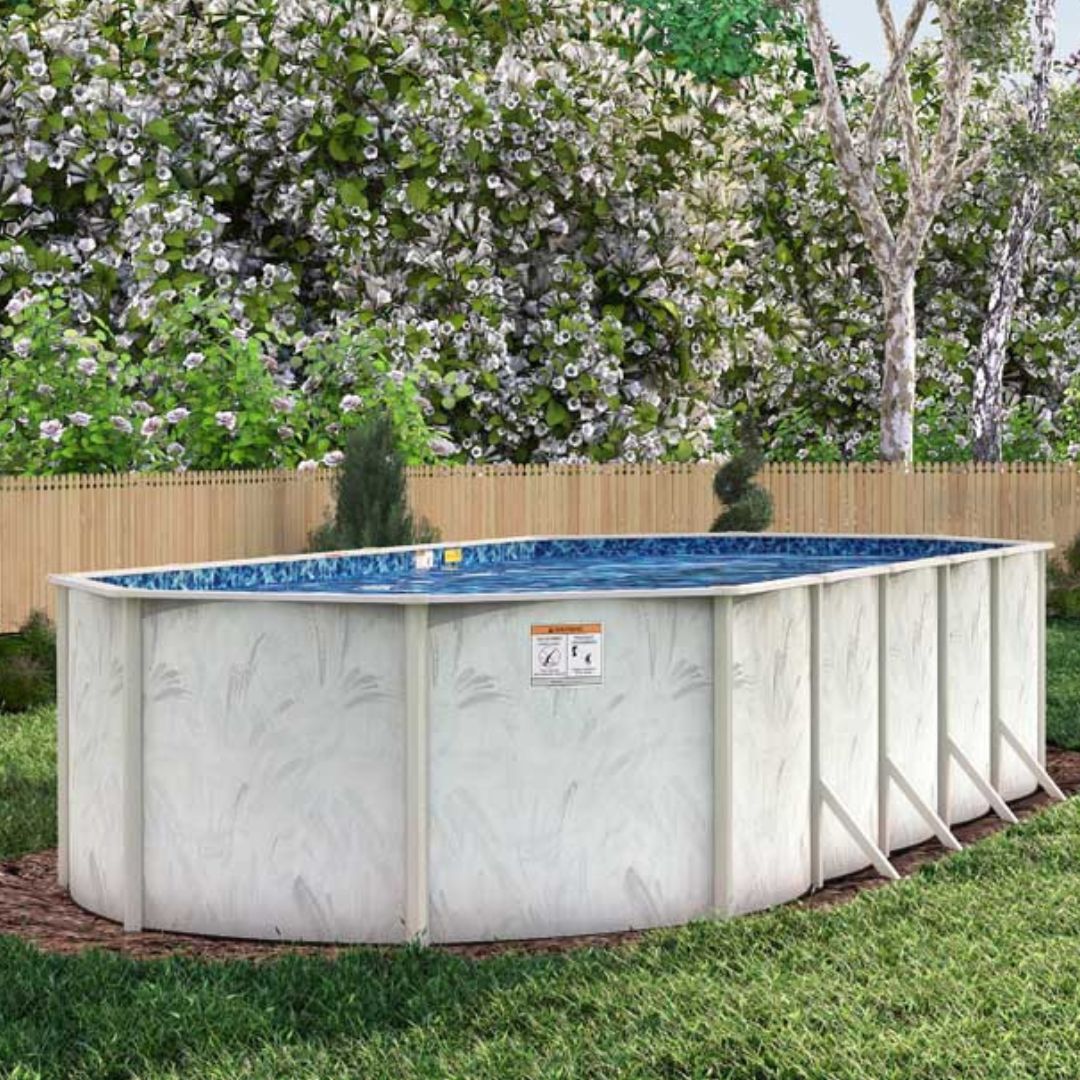 An 8' x 12' Coastal 5" Steel Frame BRACED Oval Pool & Bundle by H.I.I. Embassy stands in a grassy backyard bordered by a wooden fence, trees, and lush foliage, featuring corrosion resistance and a salt-friendly frame.