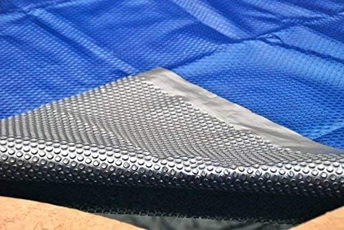 Close-up of a 24' Round Space Age Extra Heavy Duty Solar Cover by Swimming Pool Discounters, with a blue and black bubble-textured surface, partly folded to show both sides. This cover retains heat and reduces chemical use along the pool edge.