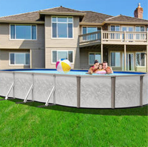 Three people enjoy swimming and playing with a beach ball in the SPD 12' x 22' x 52" Freedom Resin Frame Salt Oval Pool, set up on grass in a backyard next to a large house with a deck and many windows.