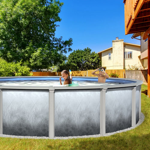 Two children enjoy swimming in an SPD 21' X 54" Mirage Resin Frame Salt Pool set up in a grassy backyard, surrounded by trees, a wooden fence, and a house in the background.